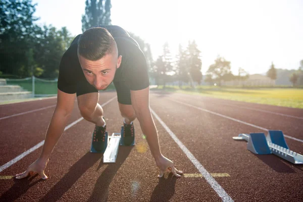 Homme athlétique sur la piste commence à courir . — Photo