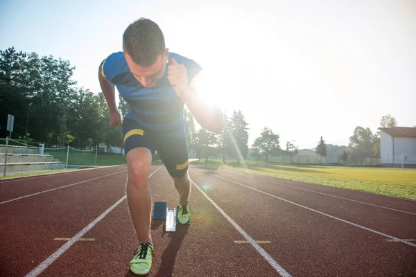 Sprinter pozostawiając bloki startowe na bieżni. — Zdjęcie stockowe