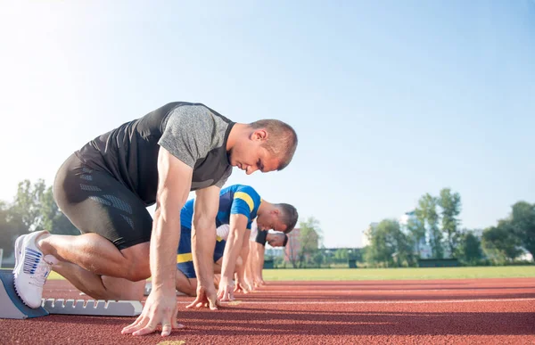 Persone pronte a correre sul campo di atletica — Foto Stock