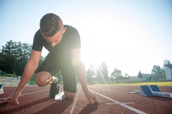 Homem atlético na pista começando a correr . — Fotografia de Stock