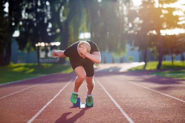 Sprinter verlässt Startblöcke auf der Laufstrecke. — Stockfoto