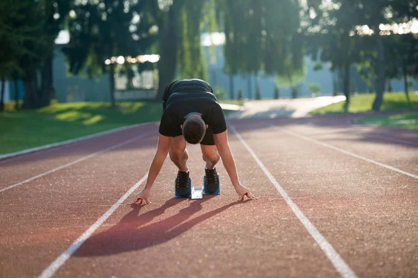 Atletisk man på spår börjar köra. — Stockfoto