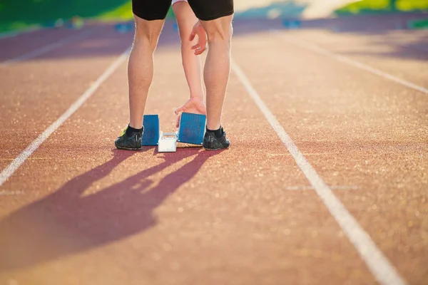 Feet of an athlete on a starting block — Stock Photo, Image