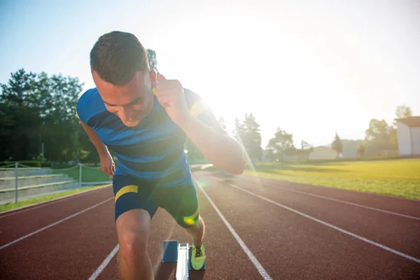 Sprinter verlässt Startblöcke auf der Laufstrecke. — Stockfoto