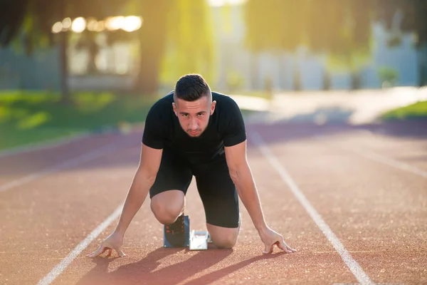 Atletisk man på spår börjar köra. — Stockfoto