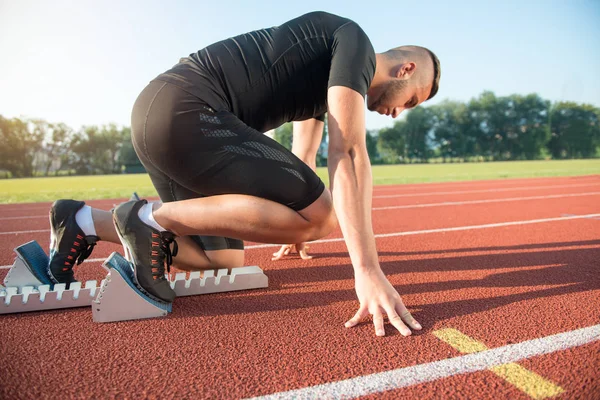 Atleta masculino na posição inicial no atletismo pista de corrida . — Fotografia de Stock