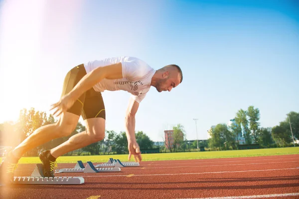 Male athlete on starting position at athletics running track. — Stock Photo, Image