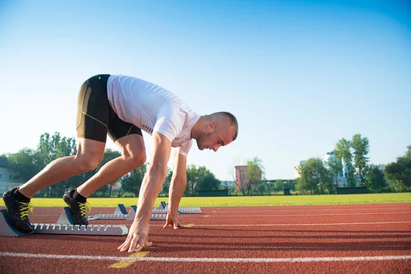 Atleta masculino na posição inicial no atletismo pista de corrida . — Fotografia de Stock