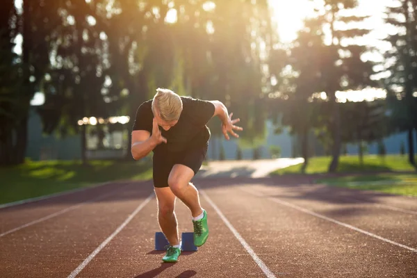 Sprinter, opustil startovací bloky na běžecké dráze. — Stock fotografie