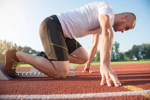 Manliga idrottare på startposition på friidrott löparbana. — Stockfoto