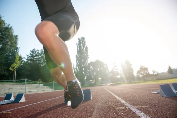 Sprinter pozostawiając bloki startowe na bieżni. — Zdjęcie stockowe