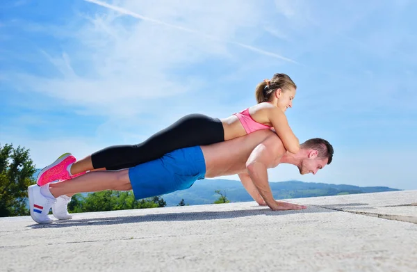 Activo joven hombre y mujer ejercitando haciendo flexiones . —  Fotos de Stock