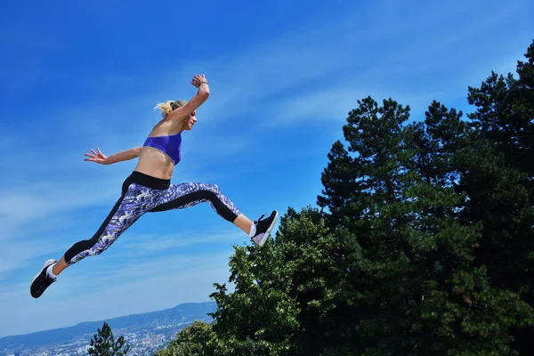 Mujer joven saltando alegremente en Park — Foto de Stock