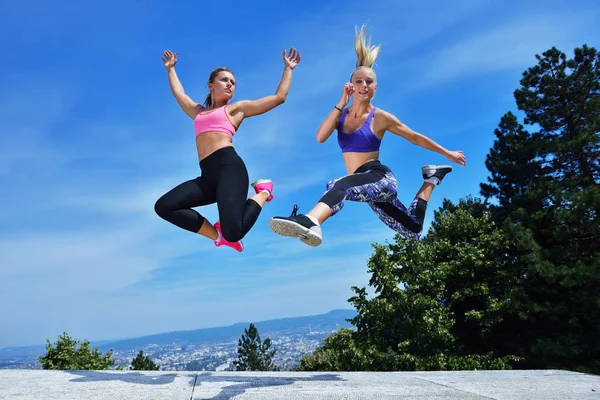 Duas mulheres jovens pulando — Fotografia de Stock