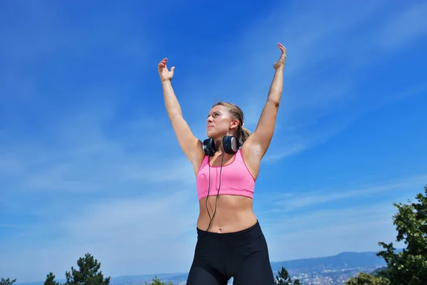 Success fitness winning woman concept with earphones. — Stock Photo, Image