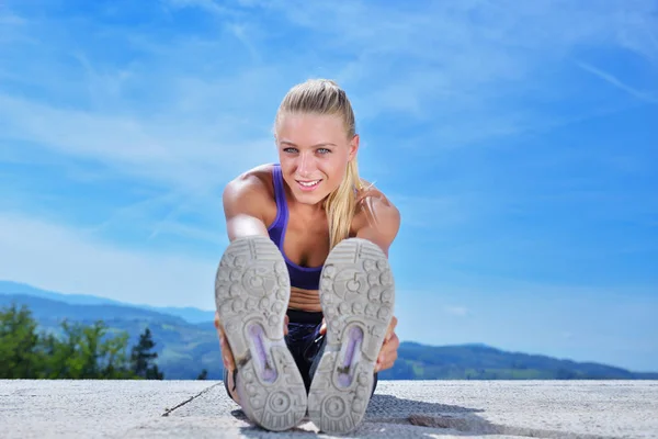 Pretty woman stretching her legs in park. — Stock Photo, Image