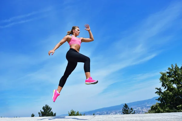 Mujer joven saltando alegremente en Park — Foto de Stock