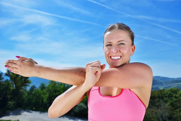 Ung kvinna stretching hennes armar upp — Stockfoto