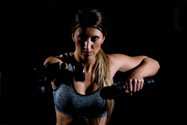 Mujer haciendo ejercicio con pesas en el gimnasio — Foto de Stock