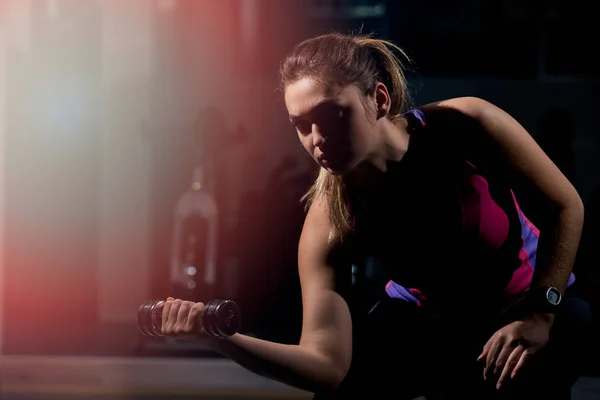 Mujer haciendo ejercicio con pesas en el gimnasio — Foto de Stock