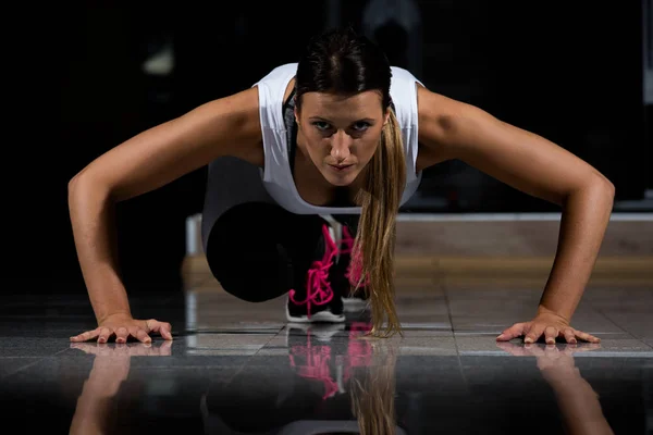 Mujer en un gimnasio haciendo ejercicio — Foto de Stock