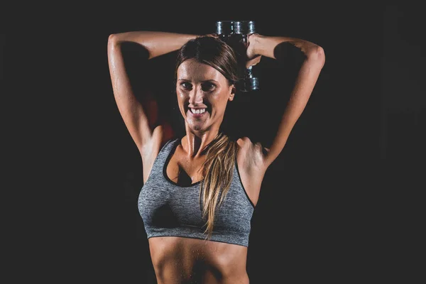 Mujer haciendo ejercicio con pesas en el gimnasio — Foto de Stock