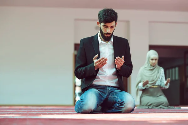 Мужчина и женщина молятся в мечети — стоковое фото