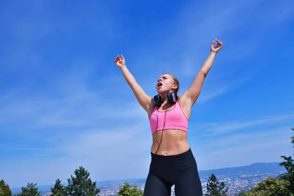 Success fitness winning woman concept with earphones. — Stock Photo, Image