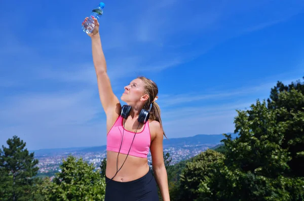 Kadın koşudan sonra su içiyor. — Stok fotoğraf