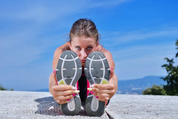 Gezonde jonge mooie vrouw, die zich uitstrekt in park. — Stockfoto