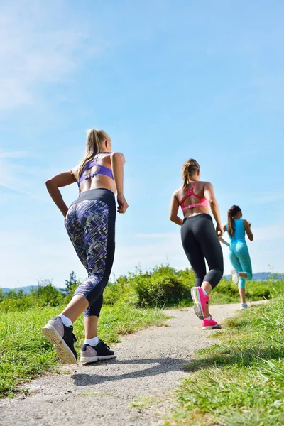 Three Joggers running together outdoors — Stock Photo, Image