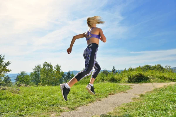 Young girl runner jogging on a mountain trail — Stock Photo, Image