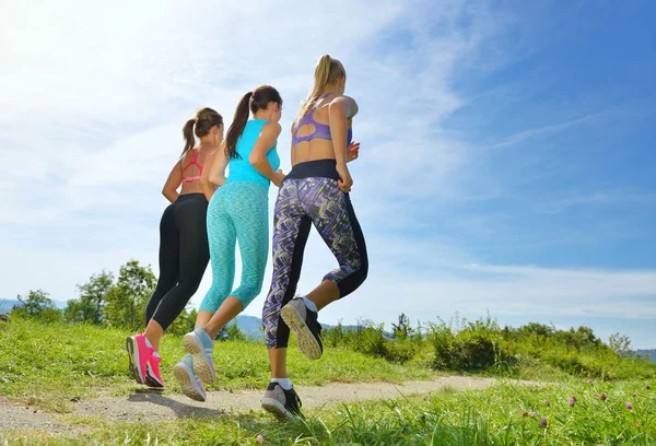 Três Joggers correndo juntos ao ar livre — Fotografia de Stock