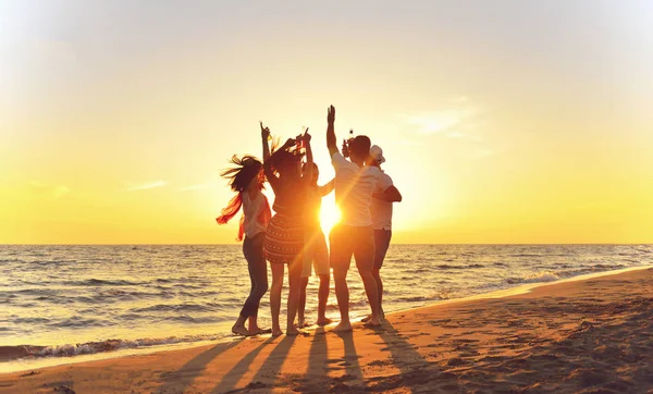 Pessoas dançando na praia ao pôr do sol — Fotografia de Stock