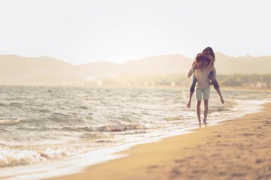 bir kızın sırtında taşıyan adam