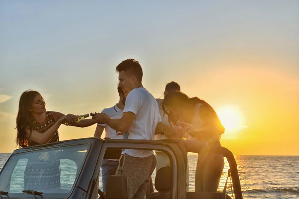 Jovens se divertindo no carro na praia — Fotografia de Stock