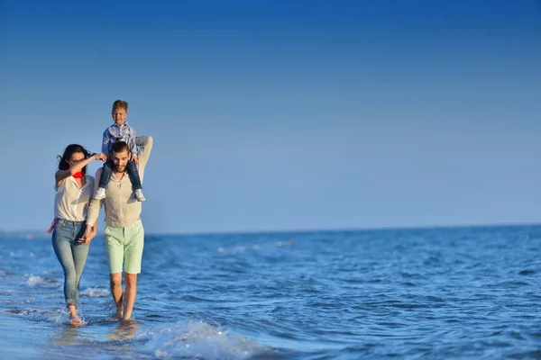 Giovane famiglia divertirsi sulla spiaggia — Foto Stock