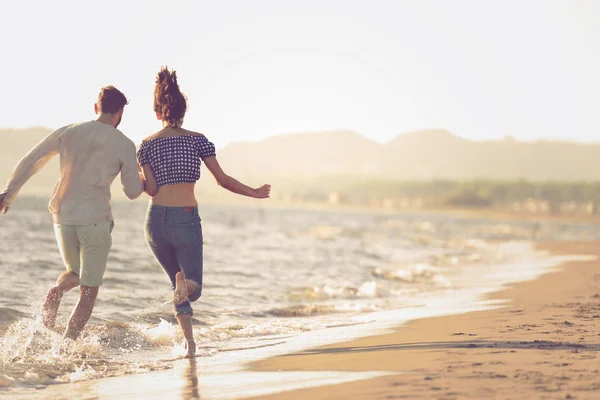 Paar rennen op het strand — Stockfoto