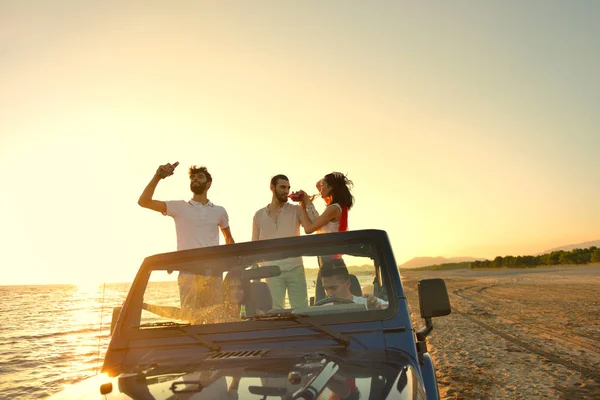 Fiatalok szórakozás autóban a strandon — Stock Fotó