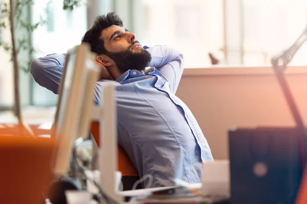 Jovem empresário descontraído no local de trabalho — Fotografia de Stock