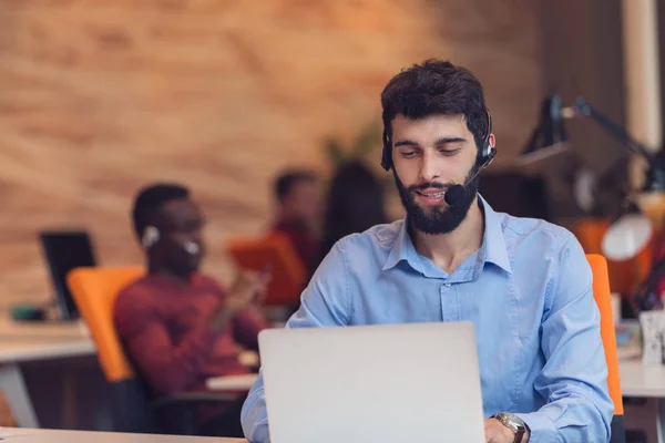 Uomo d'affari con le cuffie in ufficio — Foto Stock