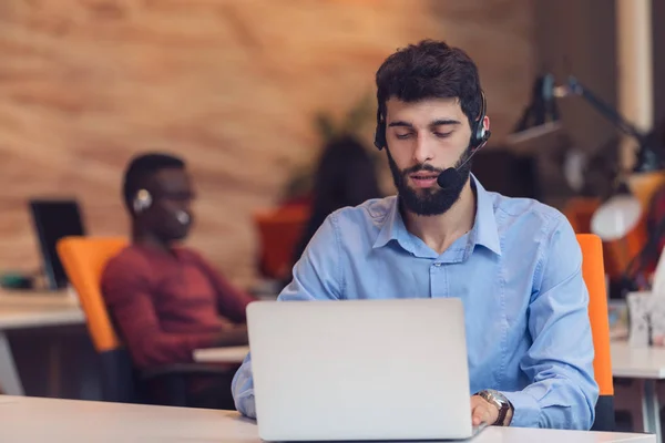 Empresario con auriculares en la oficina —  Fotos de Stock