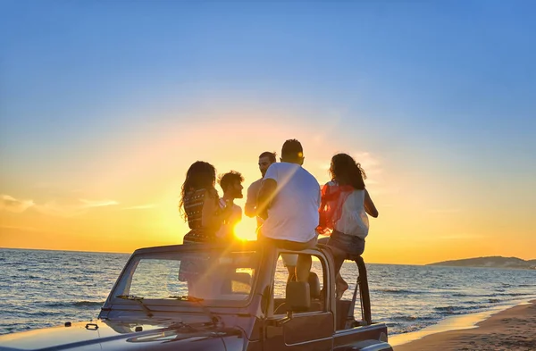 Jóvenes divirtiéndose en coche en la playa — Foto de Stock