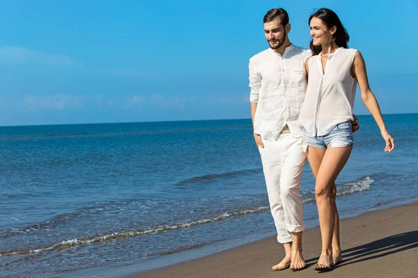 Junges Paar am Strand lächelnd — Stockfoto