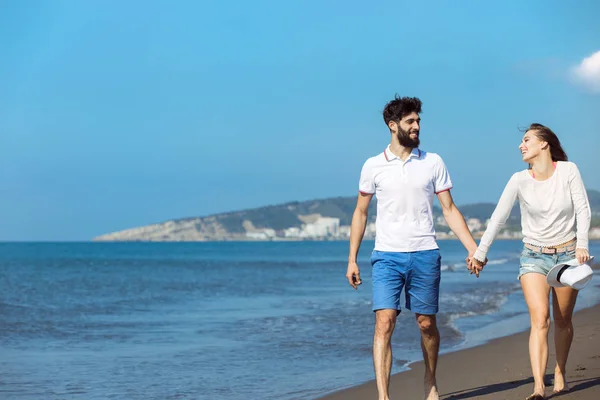 Jong koppel wandelen op het strand — Stockfoto