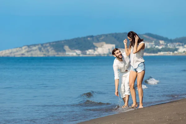Gelukkig paar loopt op het strand — Stockfoto
