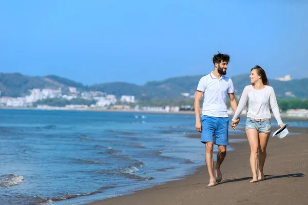 若いカップルがビーチを歩いていて — ストック写真