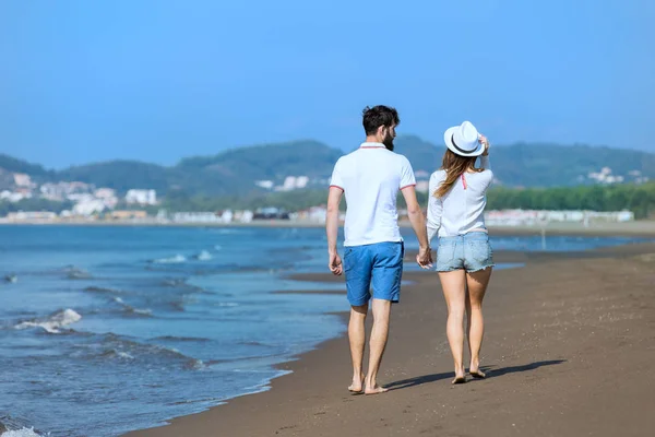 Jeune couple marchant sur la plage — Photo