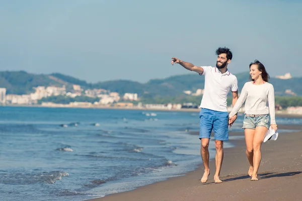 若いカップルがビーチを歩いていて — ストック写真