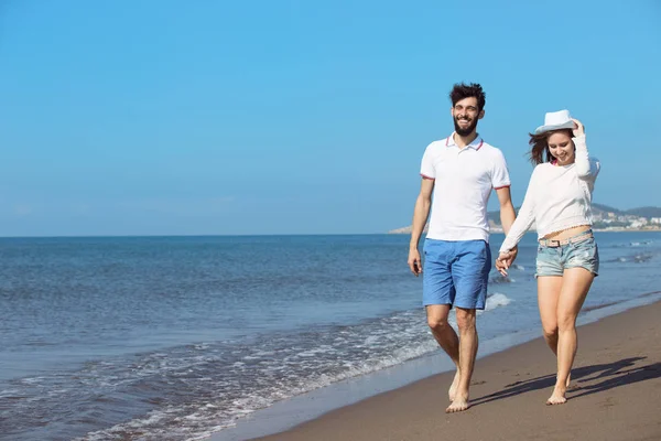 Pareja joven caminando en la playa — Foto de Stock